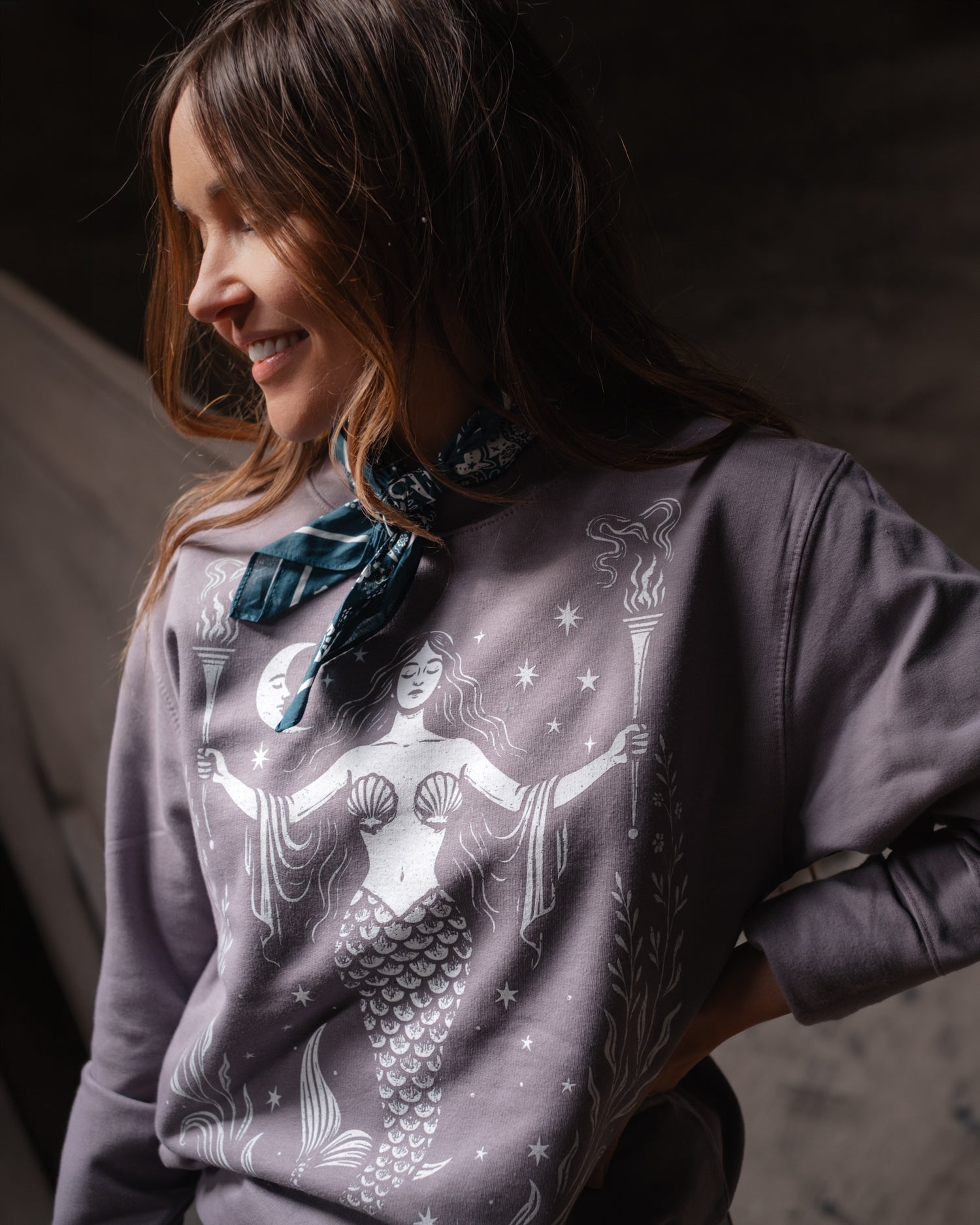 Woman wearing a lilac Art Disco sweatshirt with a mermaid design, in Whitby North Yorkshire